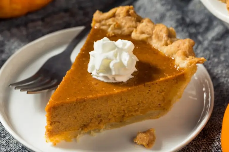 Slice of Thanksgiving pumpkin pie topped with whipped cream