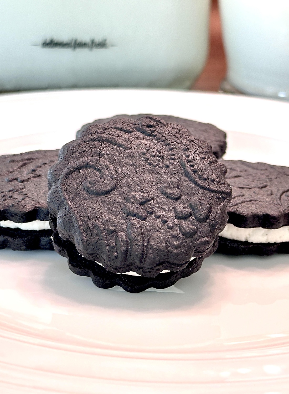 Homemade Hydrox (or Oreo) cookies on a white plate.