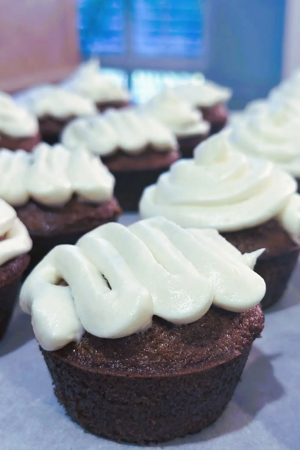 Rows of spiced carrot cupcakes topped with cream cheese frosting.