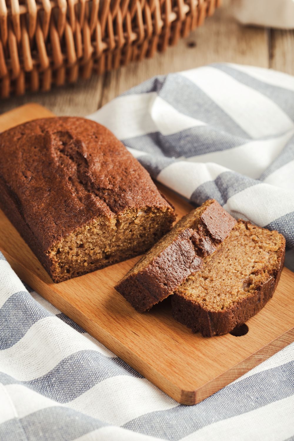 Sliced old fashioned gingerbread loaf on wooden cutting board