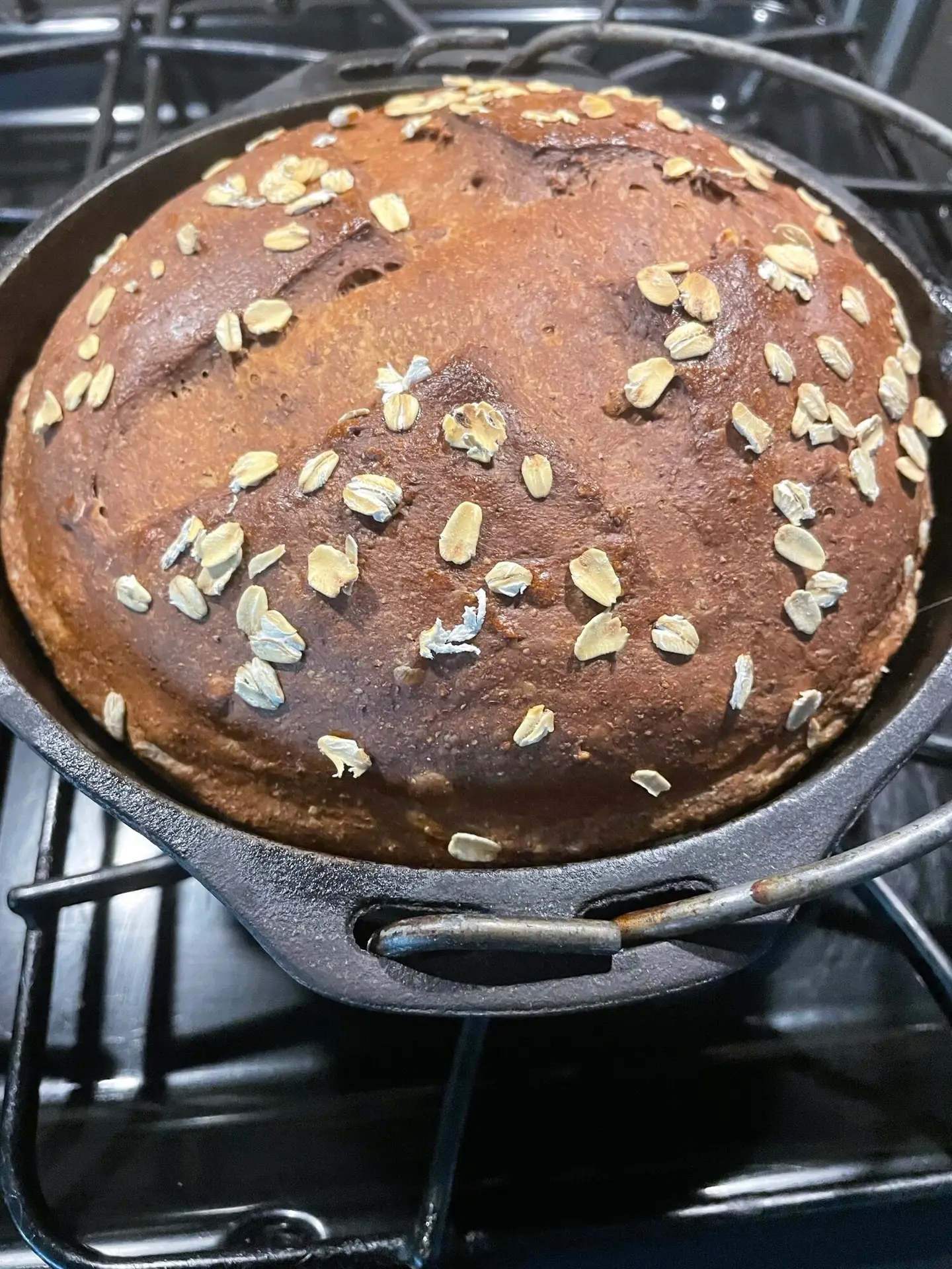 Traditional Irish beer bread with yeast baked in cast iron loaf pan with oat-topped dark crust
