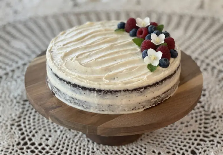 1920s Chocolate Cake with Black Cocoa frosted with vanilla icing on a wooden cake stand