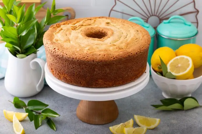 Classic lemon sponge cake on a white & wood cake stand