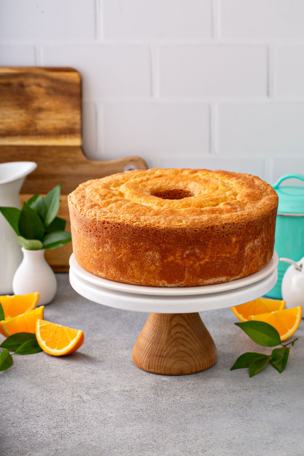 Classic lemon sponge cake on a white & wood cake stand