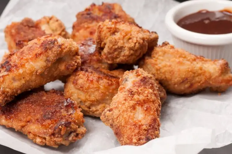 Plate of oven fried chicken wings with Ritz crackers.