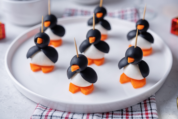 Mozzarella, carrots and black olives appetizer in the form of penguin in a plate for Christmas holidays. toning