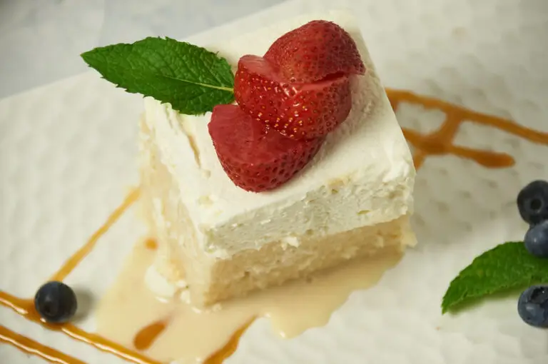 authentic tres leches cake topped with sliced strawberry