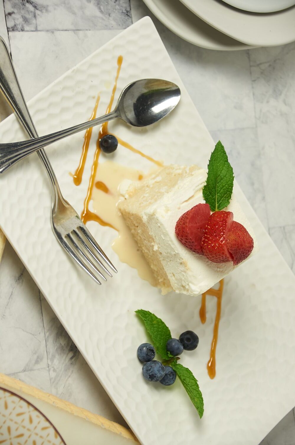 authentic tres leches cake topped with sliced strawberry