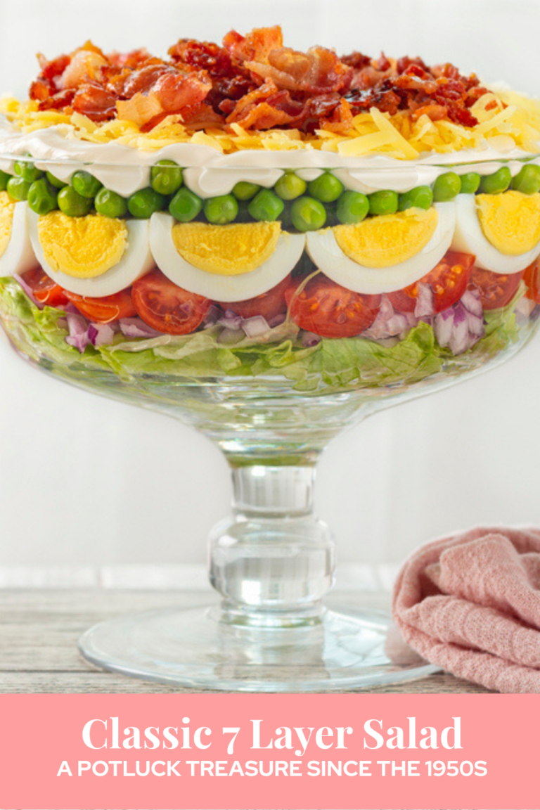 colorful classic 7 layer salad in a clear glass trifle bowl
