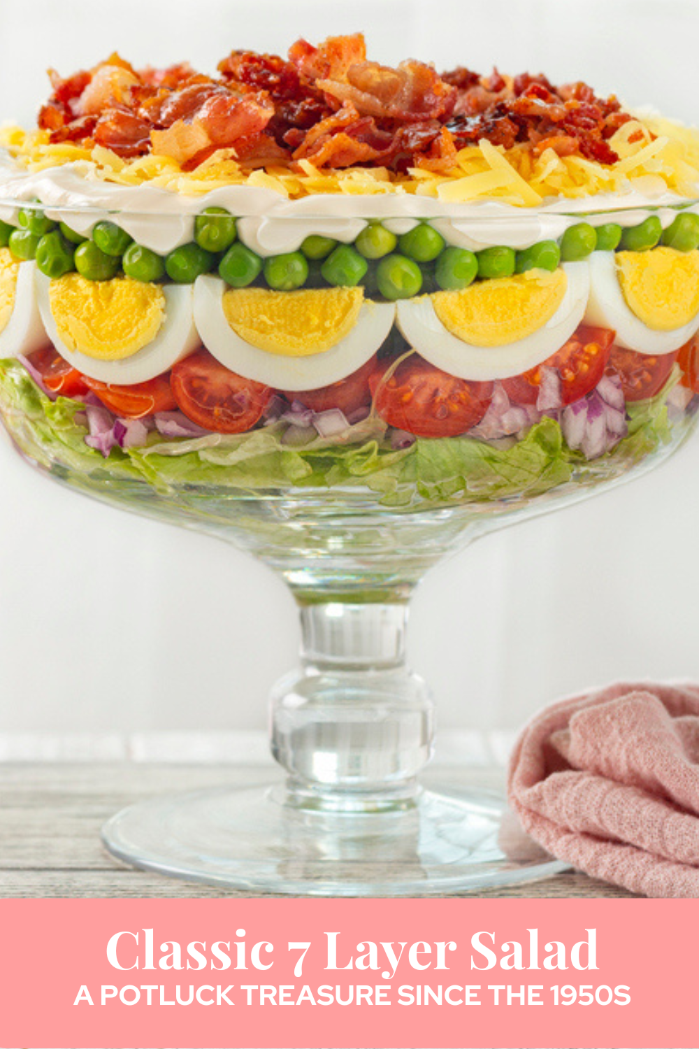colorful classic 7 layer salad in a clear glass trifle bowl
