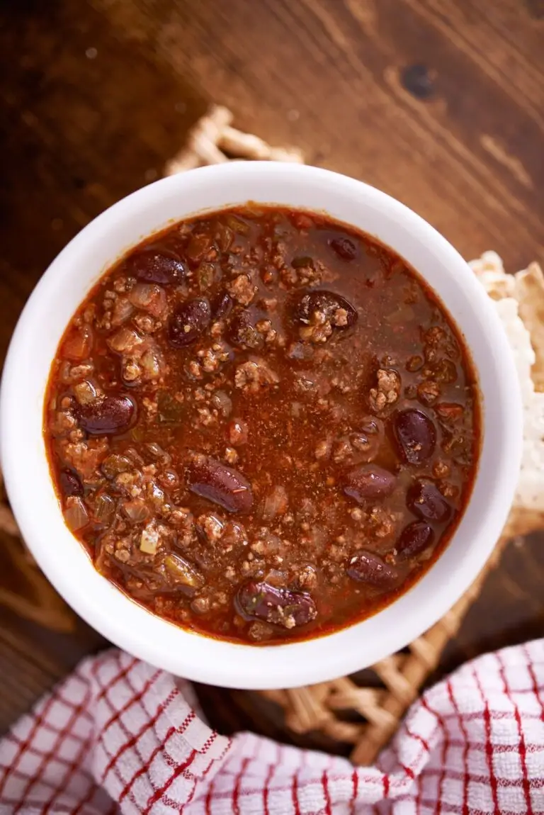 Lady Bird Johnson's Pedernales River Chili recipe from scratch served in a white bowl on a wicker mat.